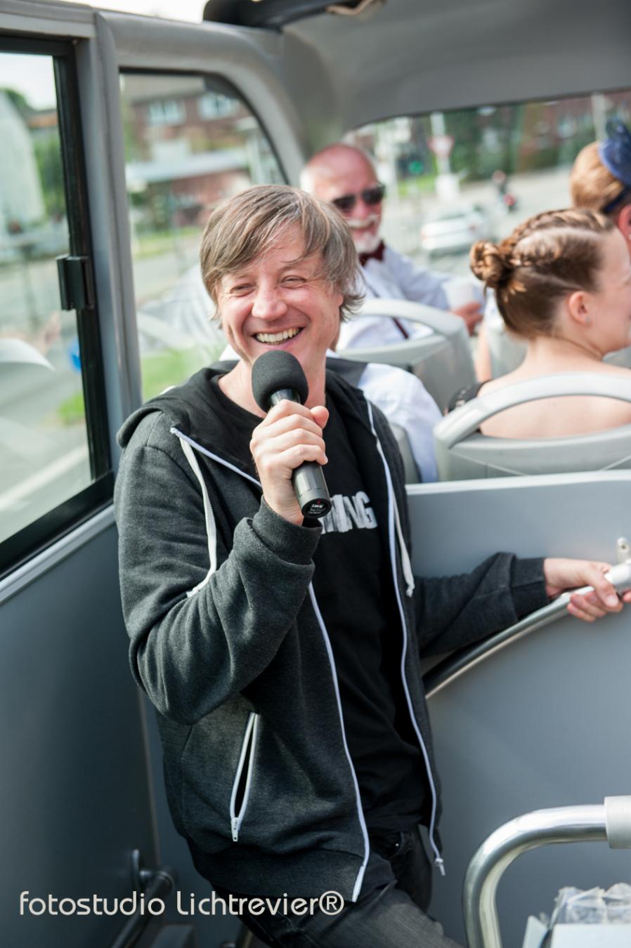Gästeführer Alexander Schwegl während einer Reiseleitung im Bus