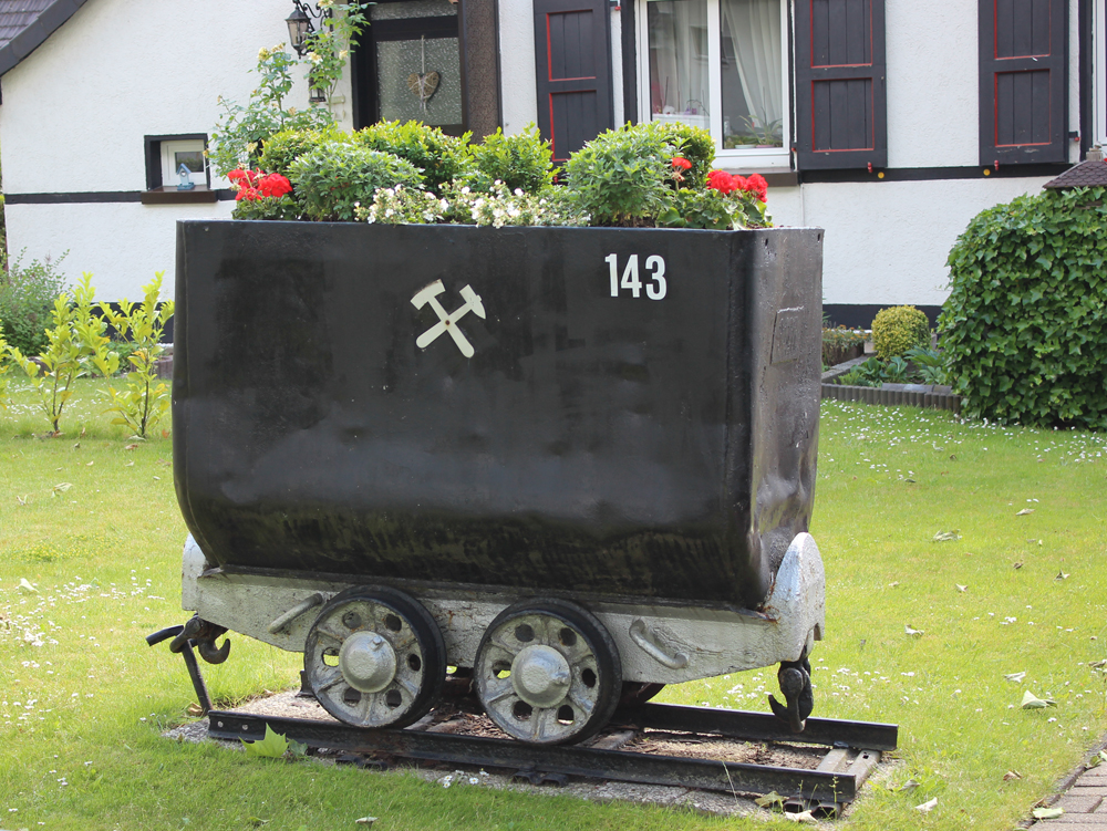 Förderwagen Ehemaliger Kohlenwagen mit Pflanzen und Blumen bepflanzt, auf einer Rasenfläche. Dahlhauser Heide, Bochum