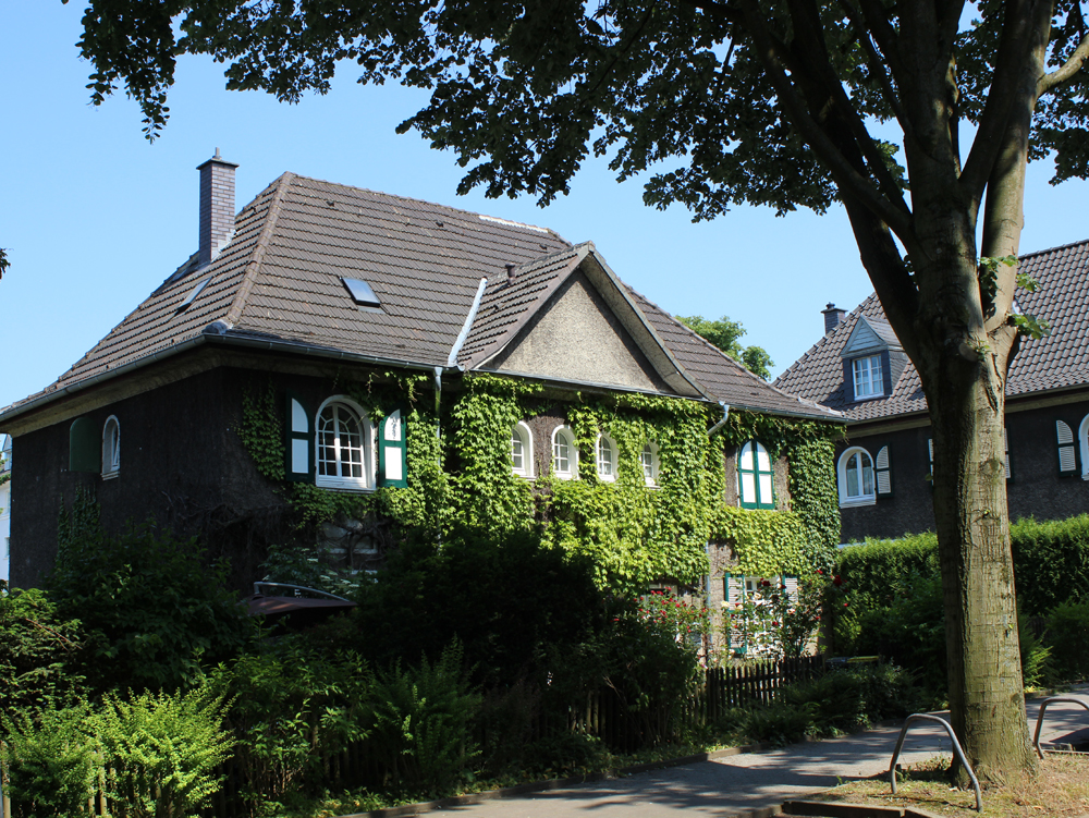 Wohnhaus Zweistöckiges Haus, umgeben von Grün, mit dekorativen Fenstern und einem Satteldach. Wohnhaus Margarethenhöhe Essen