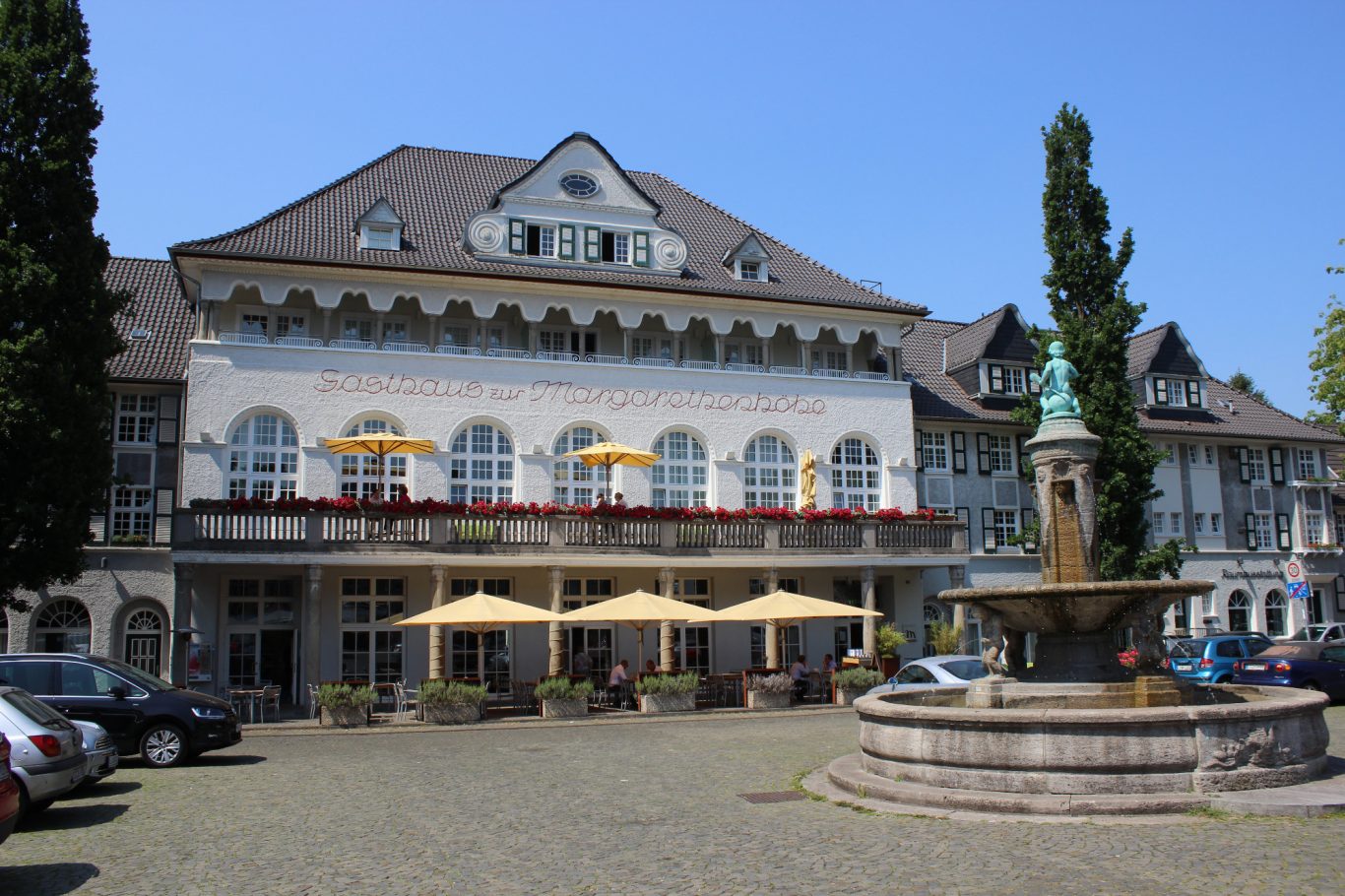 Kleiner Markt mit Schatzgräberbrunnen und Gasthaus zur Margarethenhöhe Historisches Gebäude mit Terrasse und Brunnen im Vordergrund. Kleiner Markt mit Schatzgräberbrunnen und Gasthaus zur Margarethenhöhe