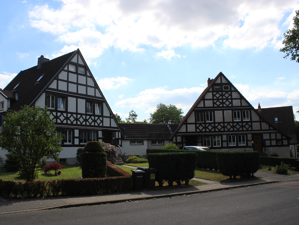 Kappeskolonie Fachwerkhäuser mit grünen Gärten und blauem Himmel im Hintergrund. Dahlhauser Heide Bochum