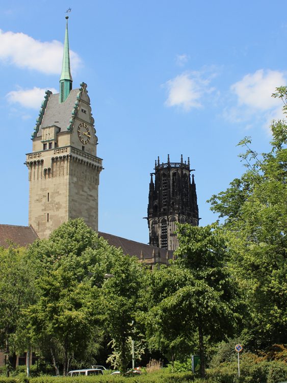 Historische Gebäude mit hohem Turm und einer grünen Spitze. Rathaus Duisburg und Salvatorkirche, Stadtrundfahrt Duisburg auf Ruhrdeutsch