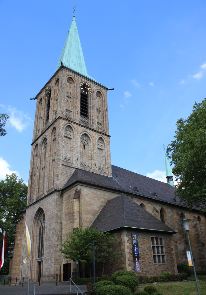 Probsteikirche Kirche mit grünem Turm und Steinfassade, umgeben von Bäumen. Probsteikirche, St. Peter und St. Paul, Bochum