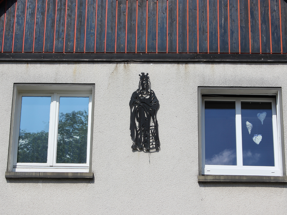 St. Barbara Figur der Heiligen Barbara zwischen zwei Fenstern an einer Hauswand. Dahlhauser Heide, Bochum